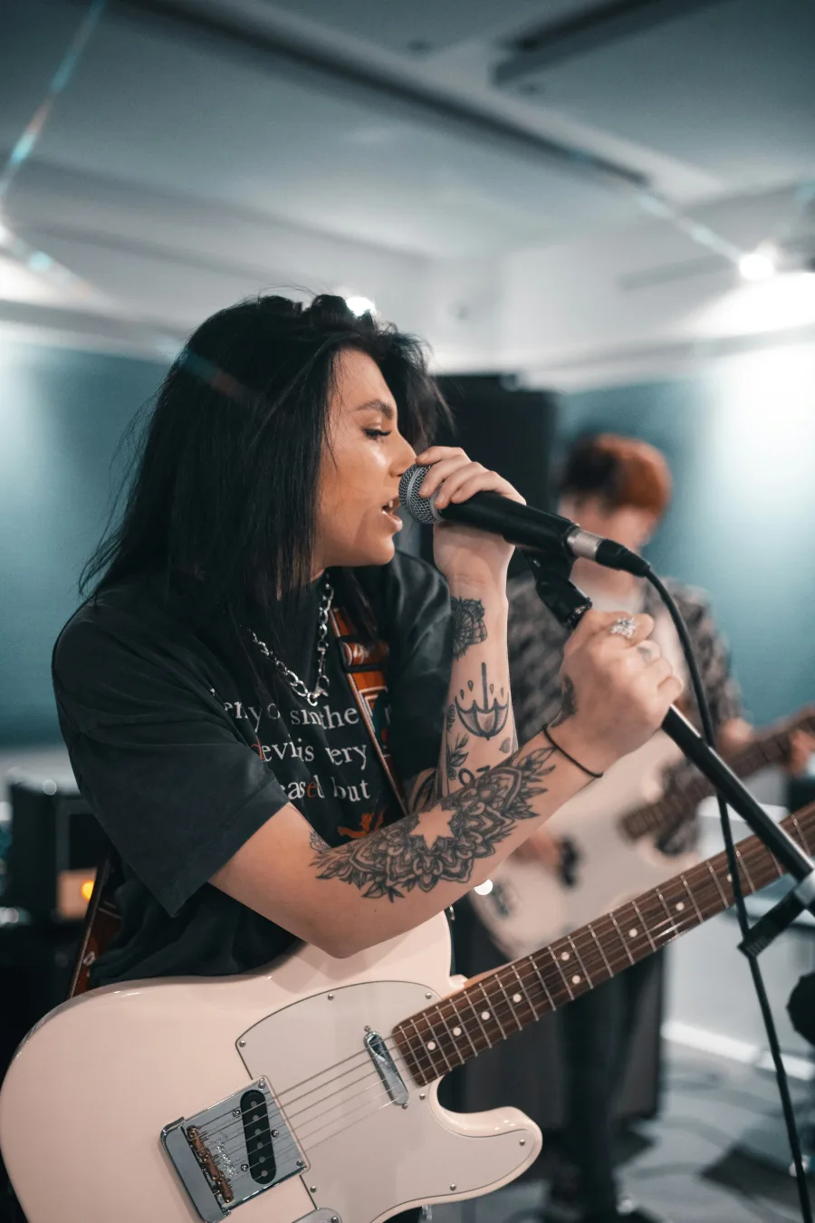 Cantante y guitarrista compartiendo un ensayo